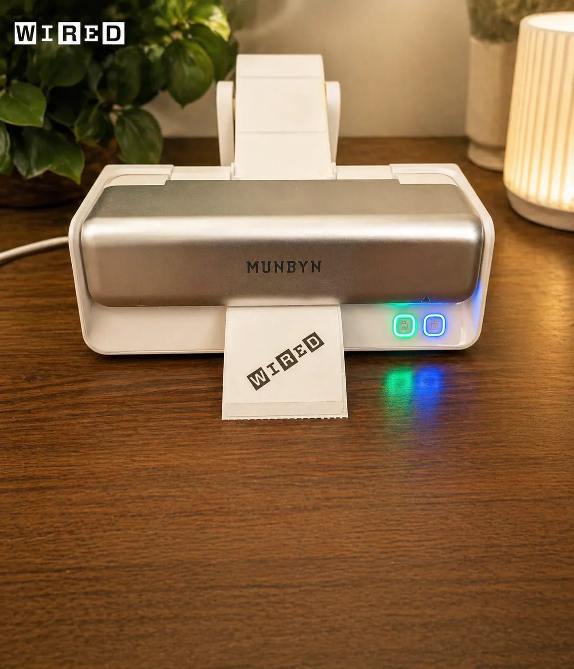 Munbyn 405B label printer printing a sheet of paper with 'WIRED' logo on a wooden surface.