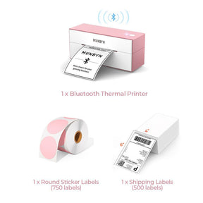 The pink Bluetooth printer kit has a pink Bluetooth shipping label printer, a roll of round labels, and a stack of fanfold shipping labels.