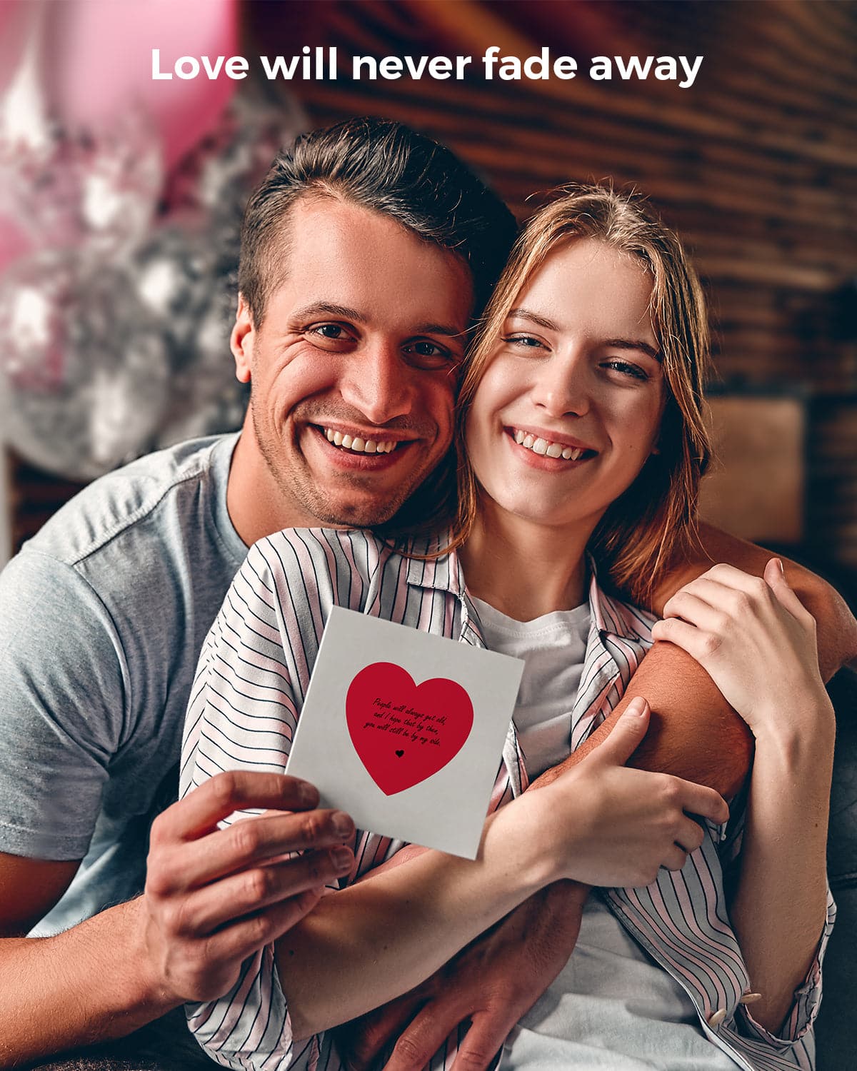 A man with his arm around a woman, holding a card with a heart sticker.